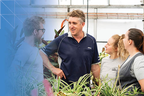 Trainer talking to students in a horticulural environment